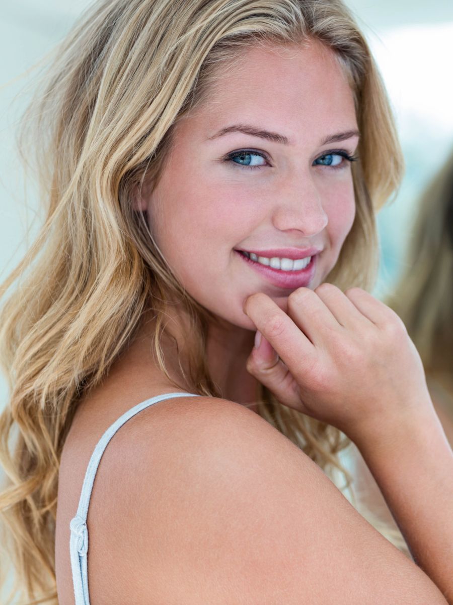 Smiling woman with long blonde hair and blue eyes.