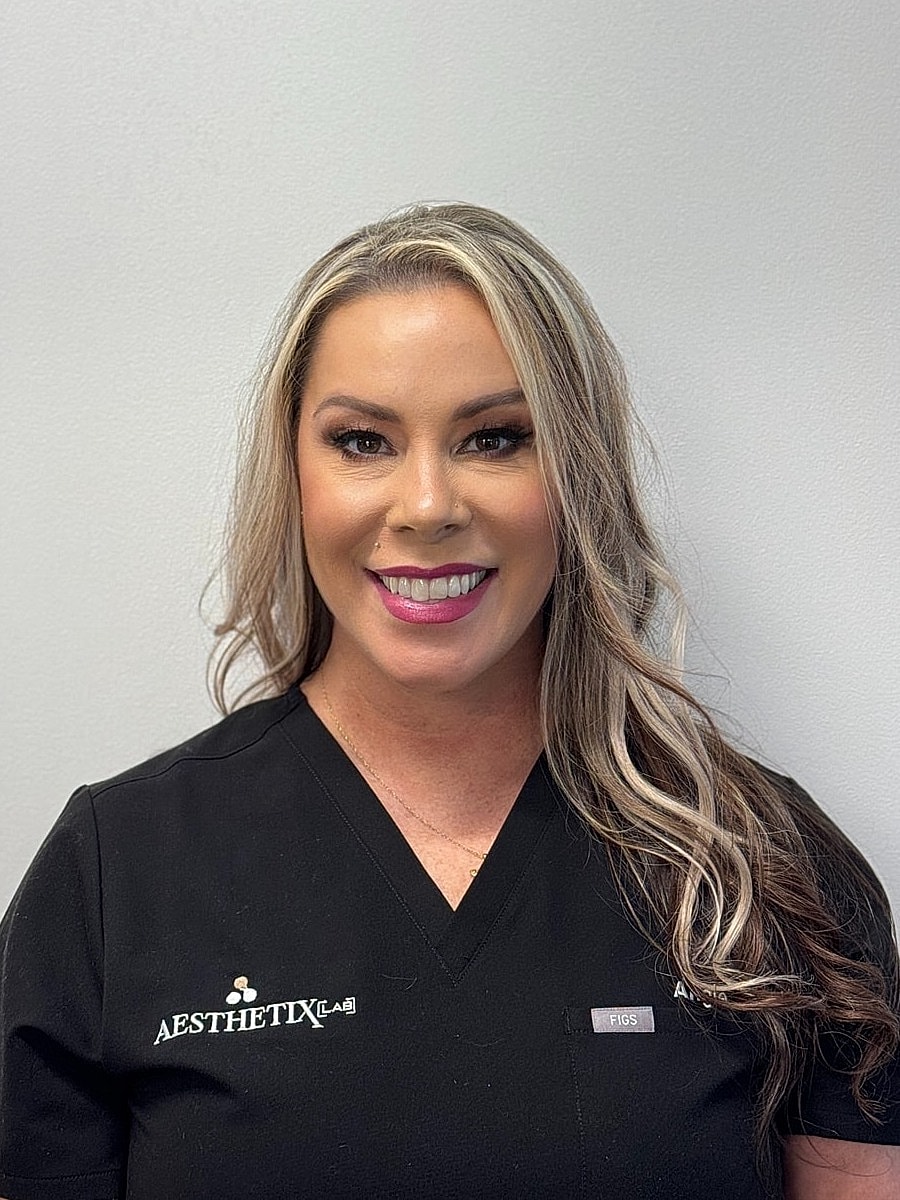 Smiling woman in black medical scrubs.